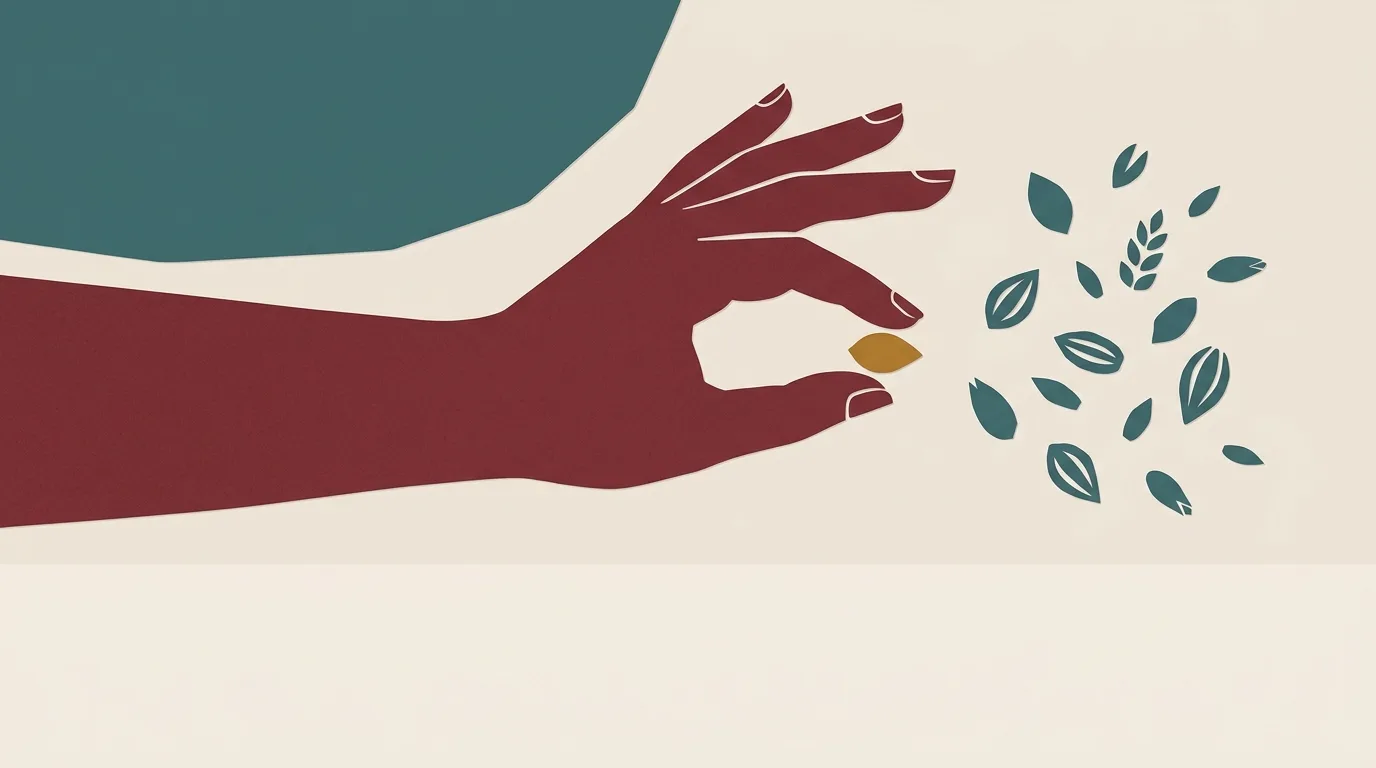 A burgundy hand selecting a small gold seed among scattered leaves.