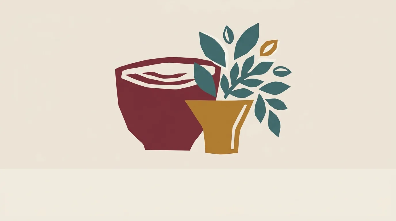 A burgundy bowl beside a gold vase holding teal leaves.